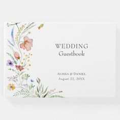 the wedding guest book is shown with flowers and leaves on it, in front of a white background