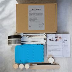 an open box containing utensils, scissors and other items to make art therapy