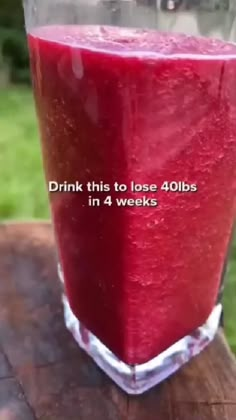 a red drink sitting on top of a wooden table