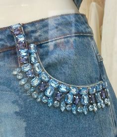 the back of a woman's jeans with blue jewels on it and an attached belt