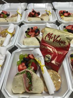 several trays filled with sandwiches and fruit on top of eachother's wrappers