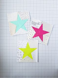 three star shaped pieces of paper on top of a piece of graph paper next to each other