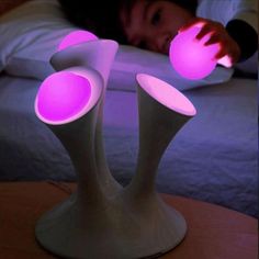 a person laying on a bed with pink lights in the shape of flower vases