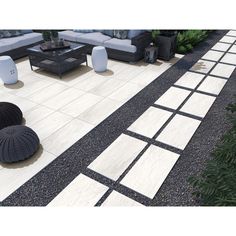 an outdoor patio area with black and white tiles on the ground, furniture and plants