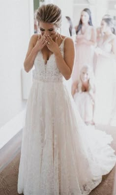 a woman standing in front of a mirror wearing a wedding dress