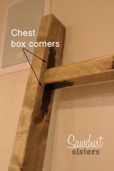 a wooden cross hanging on the wall with words above it that read chest box corners