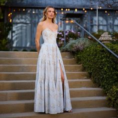 a woman in a white dress standing on some steps