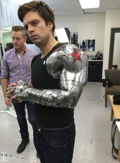 a man dressed as iron man in an office with his arm wrapped around the chest