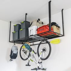 there is a bike hanging on the wall next to some storage bins and bags