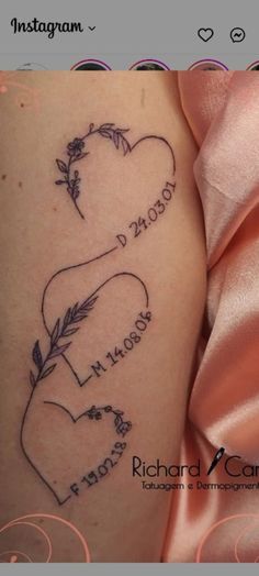 two hearts with arrows and names tattooed on the side of a woman's thigh