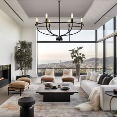 a living room filled with lots of furniture and a fire place in front of a large window