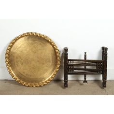 an antique brass plate next to a wooden chair