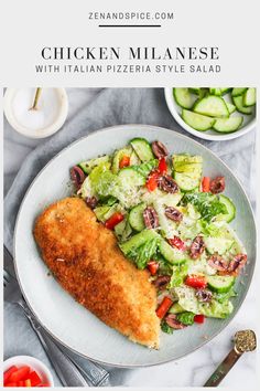 a white plate topped with chicken and salad next to a bowl of cucumbers