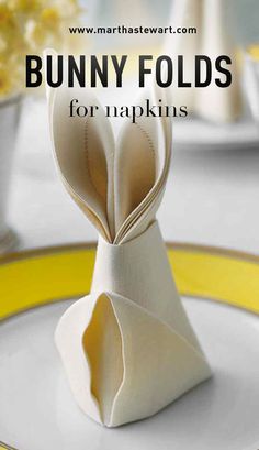 a bunny folded napkin sitting on top of a white plate