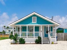 a small blue and white house on the beach