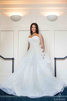 a woman in a wedding dress standing on stairs