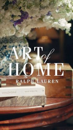 the art of home book sitting on top of a wooden table with flowers in it