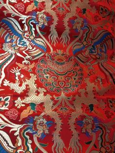 an ornate red and blue pattern on fabric