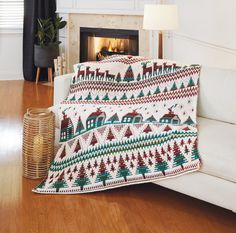 a living room with a white couch and christmas blankets on the fireplace mantels