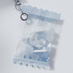 a keychain hanging from the side of a piece of clear plastic