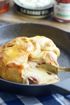 a skillet filled with cheese and meat on top of a blue checkered table cloth