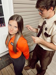 a man standing next to a woman in an orange shirt