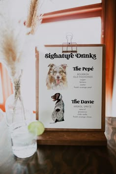 a table with a sign that says signature drinks the repe, and a dog on it