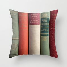 a row of old books on a white background throw pillow with red and green covers