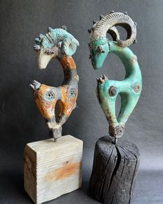 two decorative sculptures sitting on top of wooden blocks