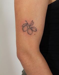 a woman's arm with a small flower tattoo on the back of her left arm