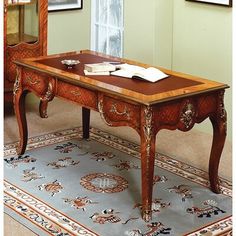 an antique desk in the corner of a room with a mirror and rug on the floor