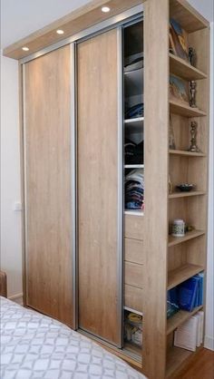 a bed room with a neatly made bed and wooden shelves