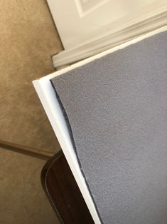 the corner of a room with a white door and gray carpeting on the floor