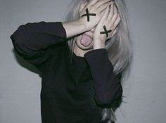 a woman covering her face with two crosses drawn on it's forehead and hands