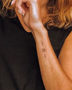 a woman with a small cross tattoo on her arm