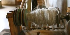 an old spinning wheel with white yarn on it