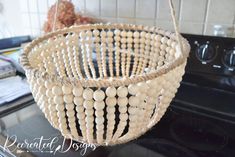 a woven basket hanging from the ceiling on a kitchen counter top with a stove in the background