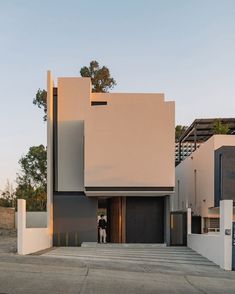 two people are standing in the doorway of a modern house that is designed to look like an art deco building