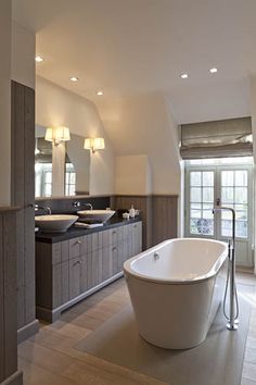 a large white bath tub sitting inside of a bathroom