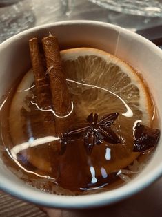 a cup filled with liquid and cinnamon sticks