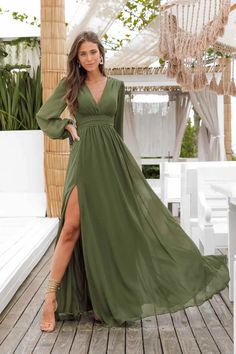 a woman in a long green dress posing on a wooden deck with her legs crossed