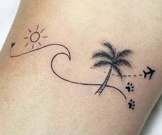 a small palm tree on the side of a woman's leg with an airplane flying over it