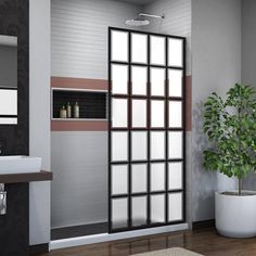 a bathroom with a toilet, sink and large glass door to another room that has a potted plant in it