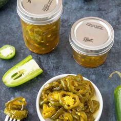 pickled jalapenos in small white bowls with spoons next to them