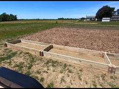 an empty wooden box sitting in the middle of a field