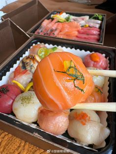 an assortment of sushi on sticks in a box with other food items around it