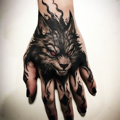 a person's hand with a tattoo on it and a wolf face painted on the palm