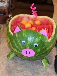 a watermelon shaped like a pig with oranges in it