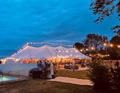 a large white tent with string lights on it