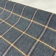 a blue and brown plaid fabric on a bed